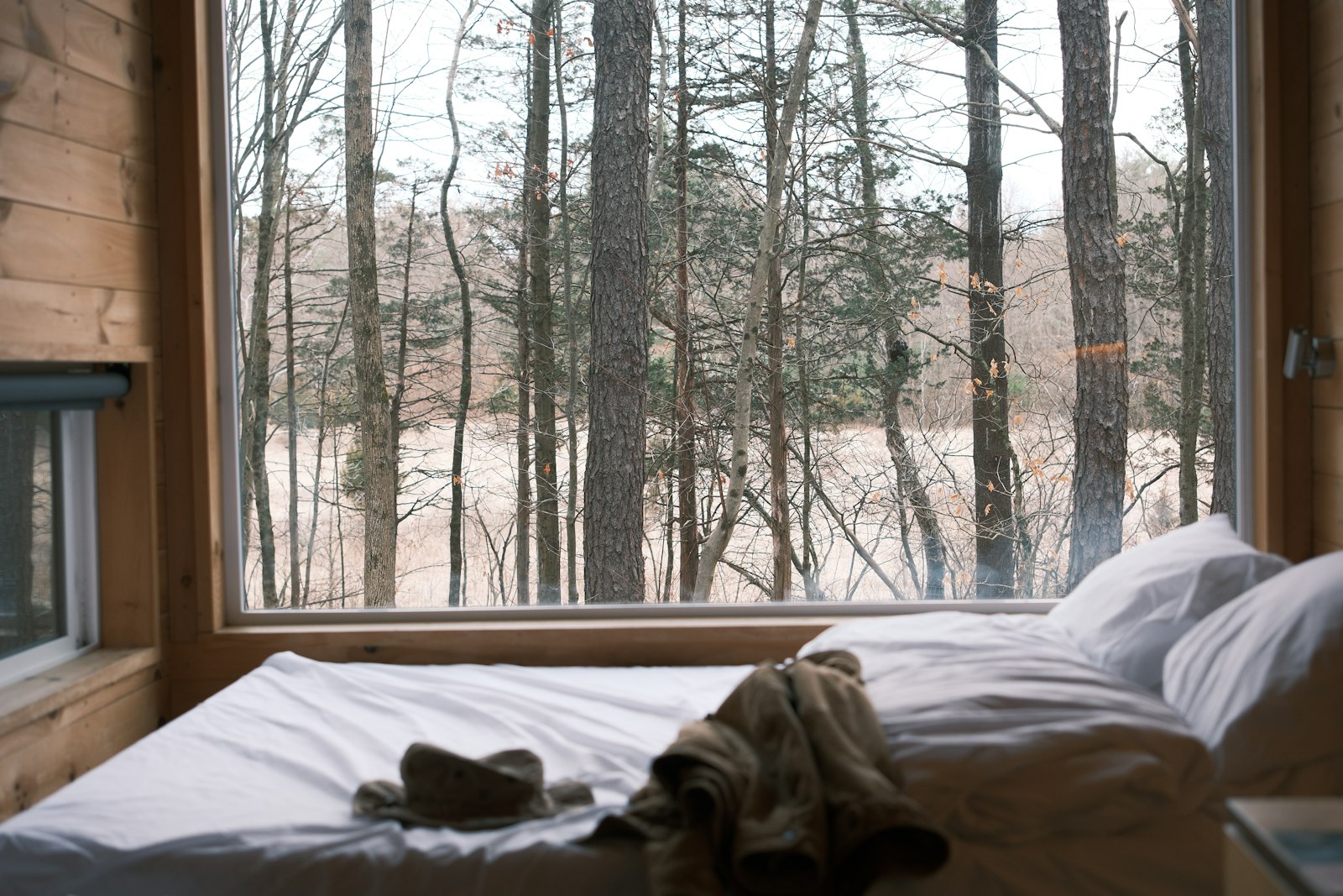 The bed beside a large window facing the water