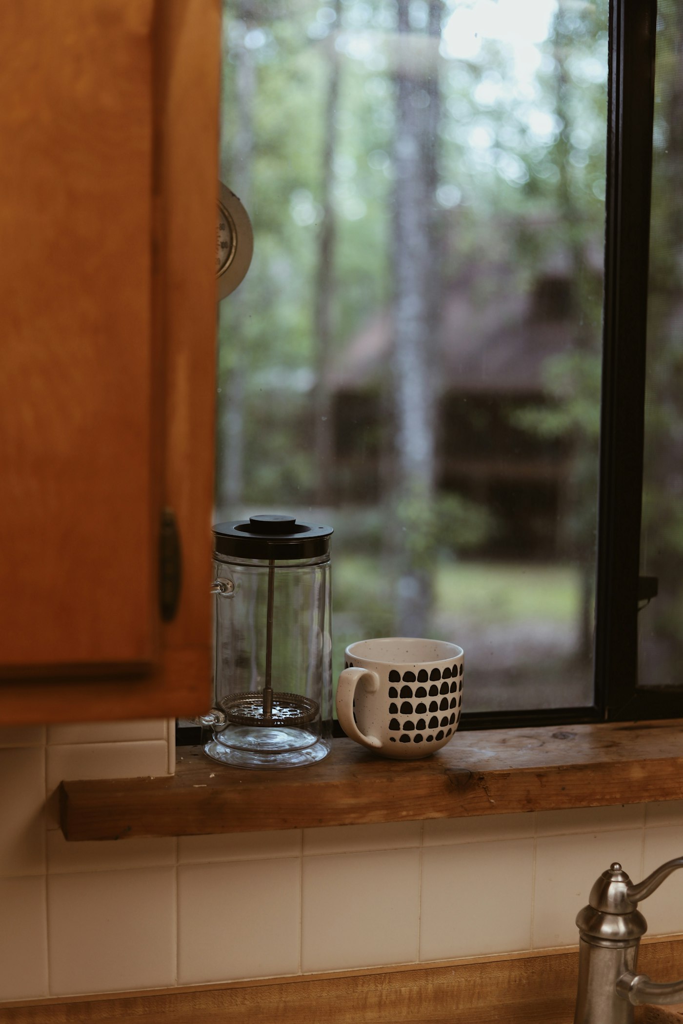 A coffee cup on the sill of a cabin window